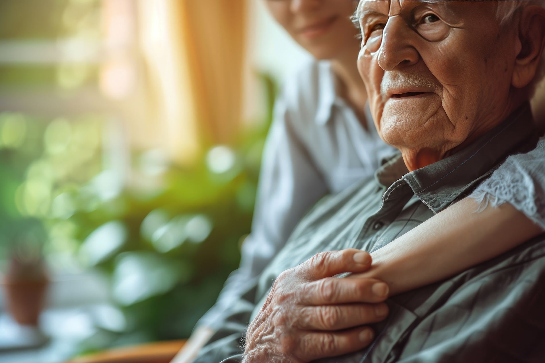 Hands of elderly man sitting in chair in nursing home